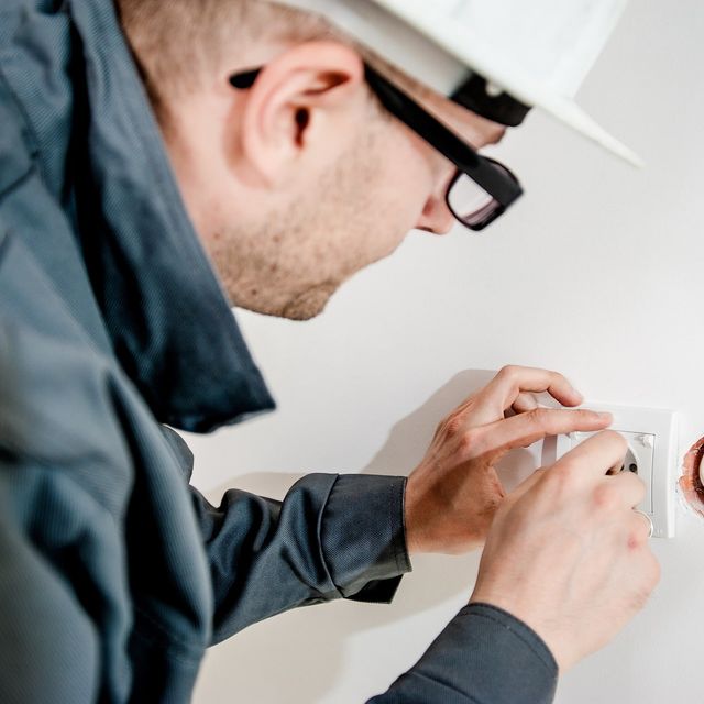 Elektriker installerer stikkontakt i vegg